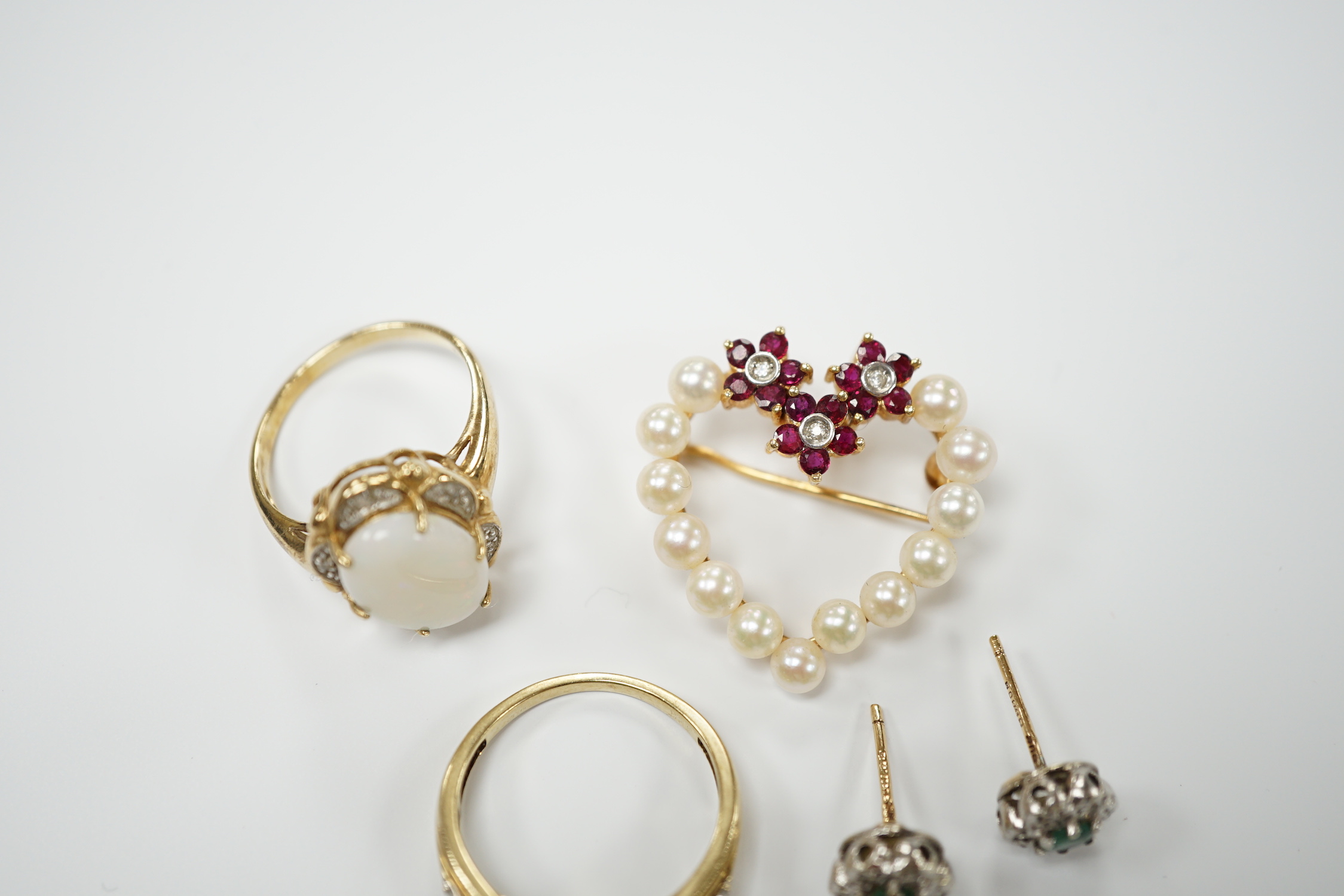 Two yellow metal and gem set rings, including diamond chip cluster and white opal and diamond chip cluster, together with a yellow metal, cultured pearl, ruby and diamond set open work heart shaped pendant brooch and a p